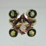 An 18 carat gold rose quartz and peridot cluster ring, set with a central cushion cut stone,