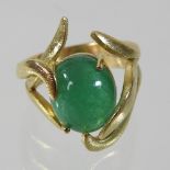 *Withdrawn* A large 18 carat gold cabochon emerald ring, with an asymmetrical scrolled setting,