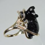 A 14 carat gold and carved black onyx ring, in the form of a cat, with diamond eyes,