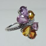 An 18 carat gold diamond and multi gem set cluster ring, set with six pear cut stones,