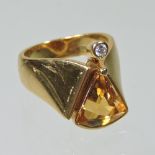 An 18 carat gold citrine and diamond ring, set with a triangular stone,