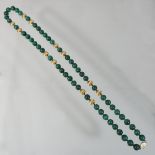 An oriental malachite single strand bead necklace, set with twelve gilt beads,