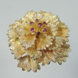 A contemporary 18 carat gold and ruby set ladies brooch, of flower head design, stamped DJE,