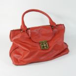 A Chloe red leather designer handbag, with black piping and a large gilt clasp,