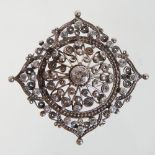 An unmarked diamond filigree brooch, of diamond shape, set with a collet set central diamond,