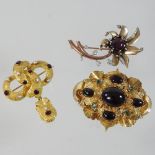 An unmarked two colour gilt, ruby and diamond brooch, in the form of a flower, 5cm overall,