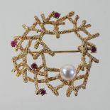 A 14 carat gold simulated coral brooch, set with a single pearl and surrounded by five rubies,