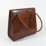 A Cartier brown leather shoulder bag, with a woven handle, panthere rings and lining,
