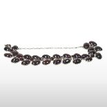An unmarked antique garnet cabochon bracelet, set with three rows of polished and cut stones,
