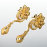 A pair of Prima 24 carat textured gold drop earrings, each of scroll and flower head shape,