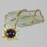 A ladies quartz designer brooch, in the form of a flower growing around a rock,