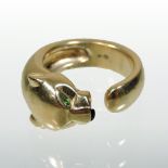 A Panthere de Cartier 18 carat gold ring, in the form of a panther, with emerald set eyes,