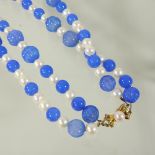 A pearl and blue glass double graduated strand necklace, with a 14 carat gold clasp,