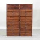An early 20th century stained pine bank of drawers,