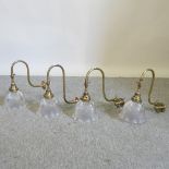 A collection of four Holophane opaque glass and brass wall lights,