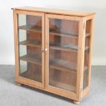 An antique pine dwarf glazed bookcase,