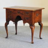 A Queen Anne style hardwood lowboy, on cabriole legs,