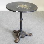 A Victorian black and floral painted occasional table, on a cast iron base,
