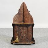 A 19th century carved oak corner cabinet, carved with a knight,