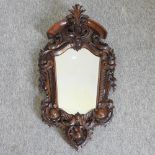 A 20th century continental ornate carved walnut framed wall mirror,