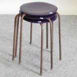 A set of three mid 20th century stacking stools, on metal legs,