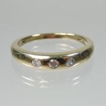A 9 carat gold three stone diamond ring, 0.15 carats gross, size Q, 3.1g gross.