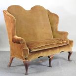 An early 20th century Queen Anne style gold upholstered high back sofa, with scrolled arms,