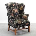 A black and floral upholstered wing armchair