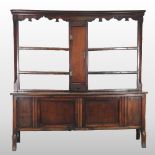 A 19th century oak dresser, the open plate rack having a shaped frieze, with cupboards below,