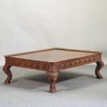 A large walnut coffee table, on hoof feet,