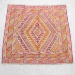 A Turkish woollen rug, with diamond pattern, on a red ground,