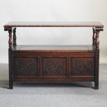 An early 20th century carved oak monk's bench,