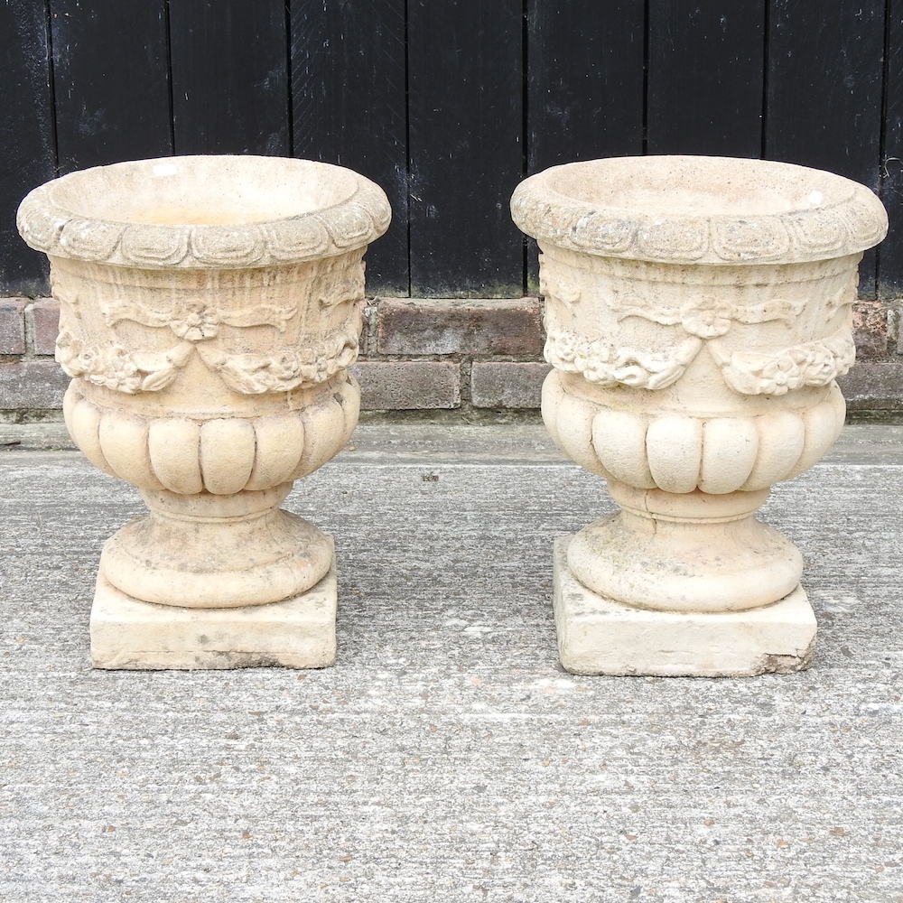 A pair of reconstituted stone planters,