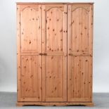 A modern pine triple wardrobe,