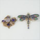An ornate gilt and purple stone set brooch, together with a silver gilt and coloured stone brooch,
