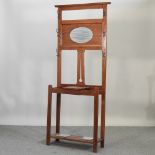 An early 20th century light oak hallstand, with an inset mirror,