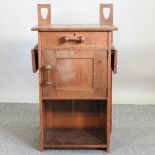 An Arts and Crafts oak cabinet, manner of Charles Voysey,