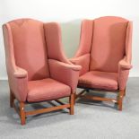 A pair of 20th century large red upholstered wing armchairs