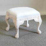 A large cream upholstered footstool, of square shape, on painted legs,