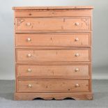 A large pine chest of drawers, with pottery handles,