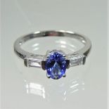 A platinum, tanzanite and diamond ring, the oval tanzanite approximately 0.