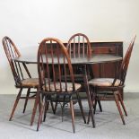 An Ercol dark elm drop leaf table, 125 x 112cm, together with four Ercol dining chairs,