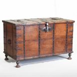 An 18th century continental elm and iron bound coffer, flanked by carrying handles, on turned feet,