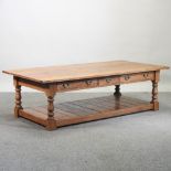 An 18th century style light oak coffee table, containing three drawers,