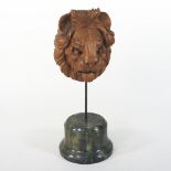 A Venetian carved walnut lion's head, mounted on a simulated marble plinth, 31cm high overall,
