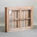 An antique pine glazed hanging cabinet,