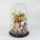 A bouquet of artificial flowers, contained under a glass dome,