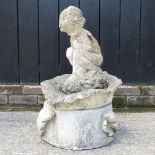 A reconstituted stone water feature in the form of a cherub, on an acanthus leaf base,