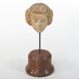 A carved limed wood head, mounted on a simulated marble plinth,