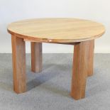 A modern light oak circular dining table,
